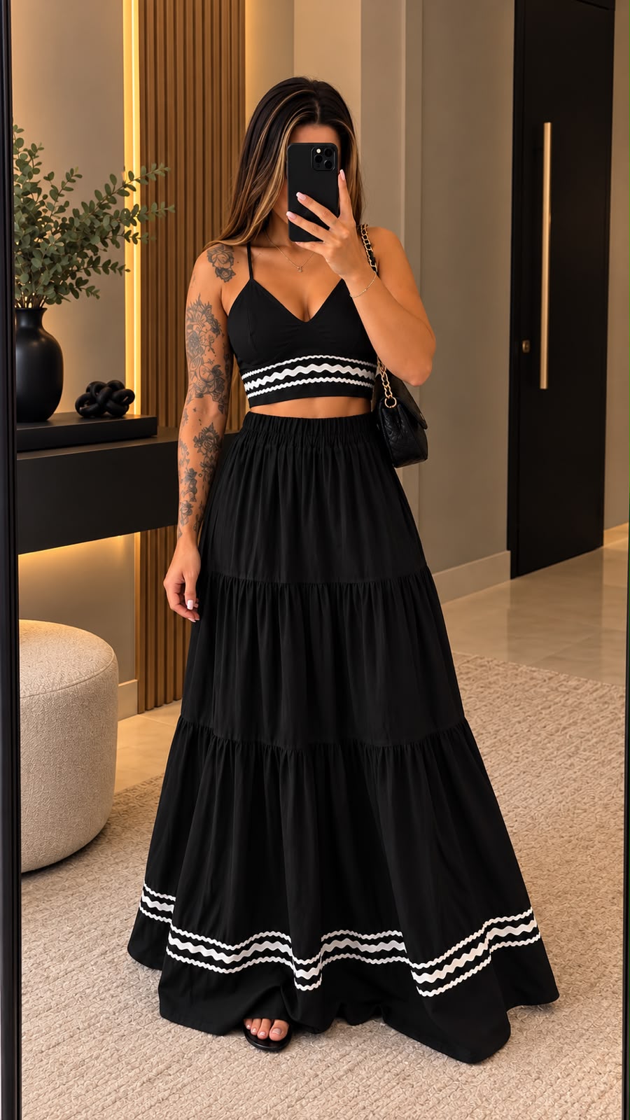 Modelo usando cropped e saia longa pretas com detalhe branco